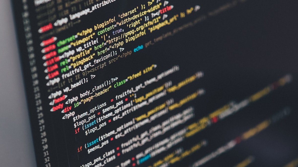 Ekran laptopa z kodem na ciemnym tle symbolizujący Linux terminal