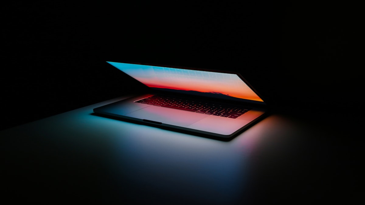 Laptop na białym biurku — widok na klawiaturę i ekran